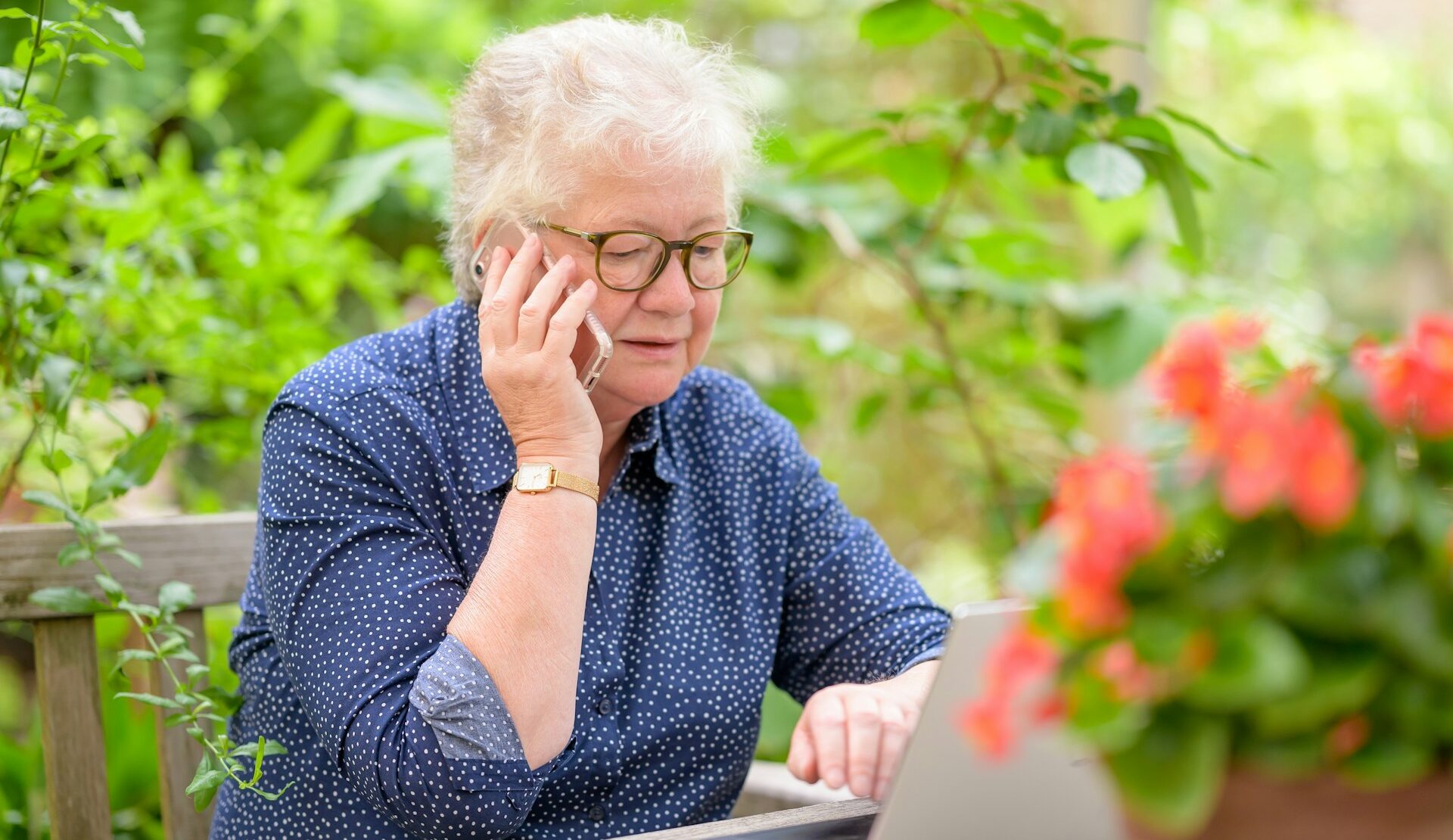 Older woman on the phone and laptop figuring out the ERISA process
