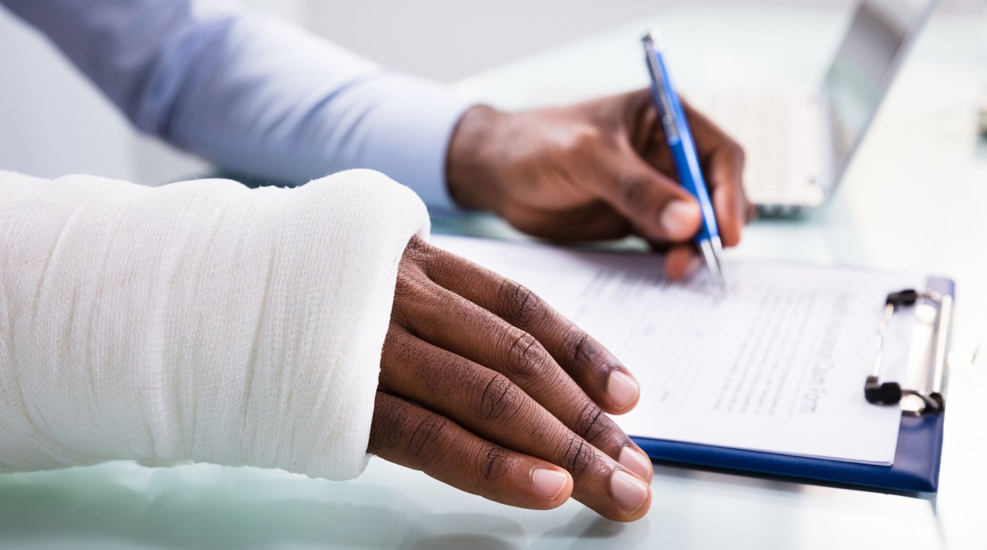 man with broken hand filling out form