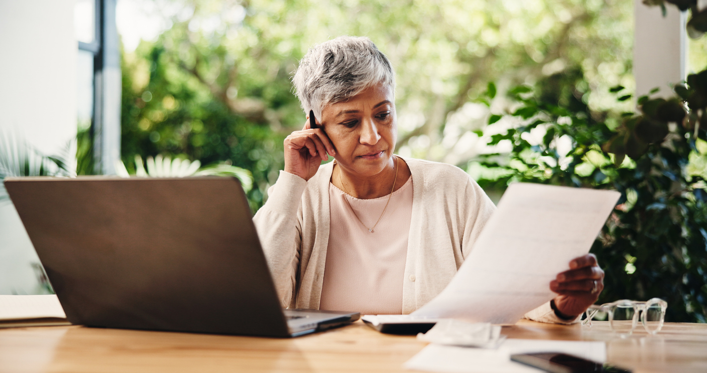 old woman at home reviewing life insurance policy denial letter